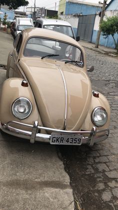 an old vw bug is parked on the street