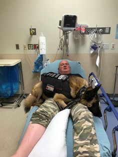 a man laying in a hospital bed with his dog