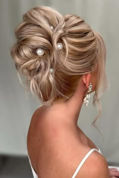 a woman with blonde hair and pearls in her hair