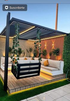 an outdoor living area with couches and potted plants on the side of it