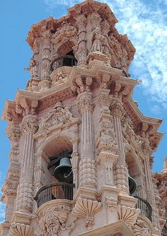 an ornate clock tower is shown against the blue sky