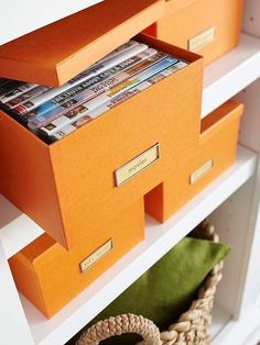 an orange shelf with magazines and other items on it's shelves, which are labeled to