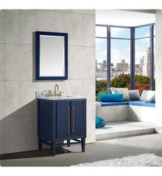 a bathroom with a blue cabinet, mirror and window seat in it's corner