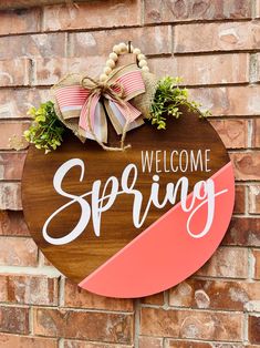 a welcome sign is hanging on the side of a brick building that says, welcome spring