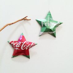 two paper stars hanging on a wall with the words coca - cola painted on them