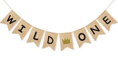 a banner that says wild one with a crown hanging from the front and bottom of it