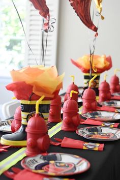 the table is set with fire hydrants, plates and napkins for each place setting