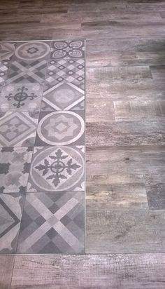 the floor is made up of wood and has an intricate design on it, as well as a glass door