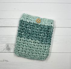 a green and white crocheted case sitting on top of a wooden table