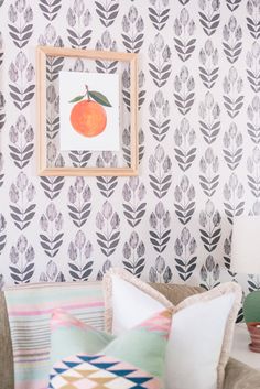 a living room filled with furniture and wallpaper covered in oranges on the wall