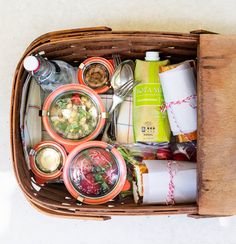 a picnic basket filled with food and drinks