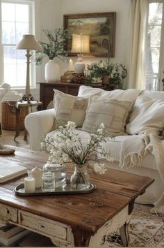 a living room filled with furniture and lots of white flowers on top of a coffee table