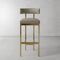 a modern bar stool with an upholstered seat and backrest in gold metal