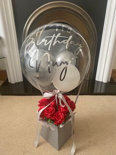 a birthday balloon and some red roses in a box