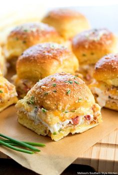 small sandwiches with meat and cheese on a cutting board