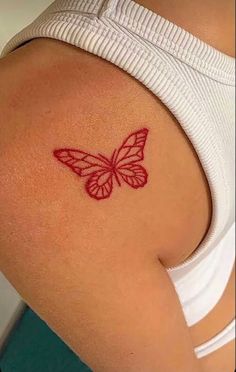 a woman with a butterfly tattoo on her back shoulder and lower arm, behind her is a white tank top