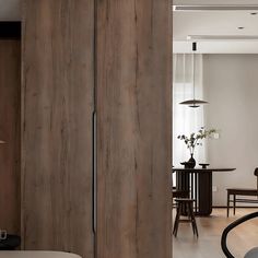 the interior of a modern apartment with wood paneling and white walls, including a dining table