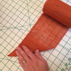 someone is making a piece of orange fabric