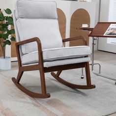 a rocking chair sitting on top of a rug next to a table