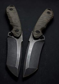 two knifes are laying side by side on a black surface