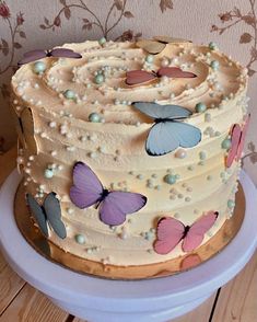 a cake decorated with butterflies and pearls on a plate