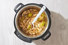 an overhead view of a crock pot filled with food and a spoon in it