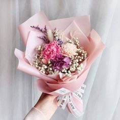 a person holding a bouquet of flowers in their hand