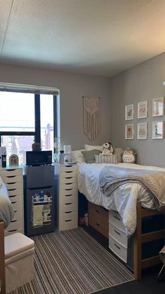 a bedroom with a bed, dressers and other items on the floor in front of a window