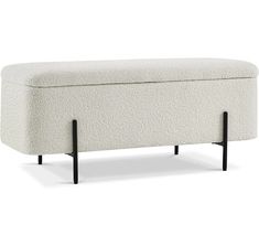 an upholstered bench with black legs and a white blanket on the backrest