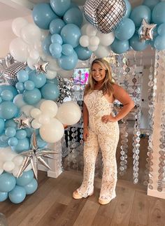 a woman standing in front of some balloons