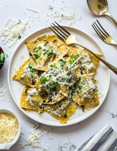 a white plate topped with ravioli covered in cheese