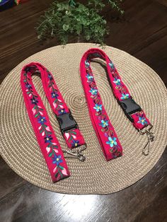 two leashes are sitting on top of a round mat with plants in the background