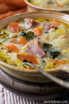 two bowls of soup with carrots, potatoes and ham in the middle on a table