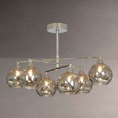 a chandelier with five clear glass balls hanging from it's ceiling fixture