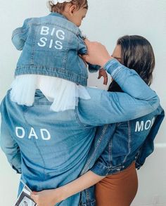 a woman holding a child in her arms with the words big siss on it