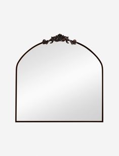 a mirror with an iron frame and flowers on the top, against a white background