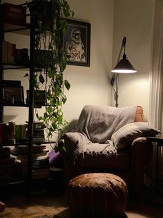 a living room with a couch, chair and bookshelf in the corner at night