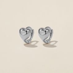 Heart goes padam padam in these hoops. Boo’s chubby heart motif, set on a 6mm huggie, are the sweetest addition to your ear stack. Minimal, sophisticated and chic, these shapely hoops will have hearts skipping beats. Created for you in the finest 14 karat white gold, you'll want to wear these earrings always and never take them off, even when working out or in the shower. Sterling Silver Huggie Heart Earrings For Pierced Ears, Elegant Everyday Huggie Heart Earrings, Elegant Everyday Heart Huggie Earrings, Valentine's Day Minimalist Huggie Earrings, Valentine's Day Tarnish Resistant Huggie Earrings, Everyday Huggie Earrings For Valentine's Day, Trendy Huggie Earrings For Valentine's Day, Everyday Huggie Heart Earrings With Charm, Sterling Silver Heart Earrings Tarnish Resistant For Everyday