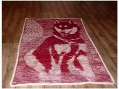 a red and white rug with an image of a dog on it's back