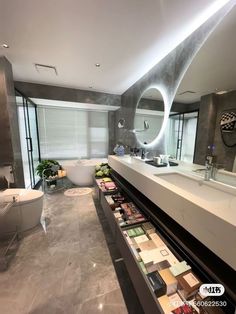 a bathroom with a tub, sink and large mirror