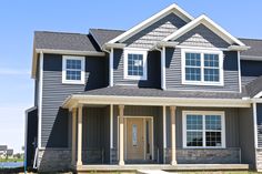 a house with gray siding and white windows