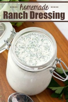 homemade ranch dressing in a mason jar on a cutting board with fresh herbs around it