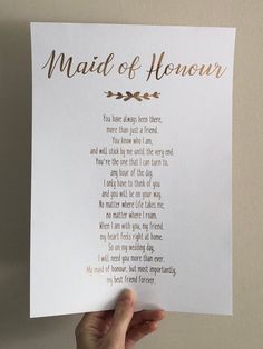 a hand holding up a piece of paper with the words maid of honor written on it