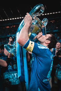 a man is holding up the trophy in front of his face as he kisses it