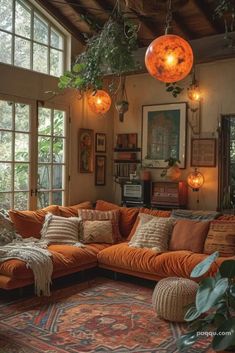 a living room filled with lots of furniture and plants hanging from the ceiling above it