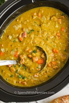 a crock pot filled with ham and lentil soup next to a piece of bread