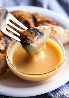 a fork lifting up some food out of a small glass bowl on a white plate