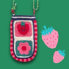 a crocheted purse with two strawberries hanging from it's sides on a green background