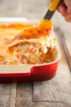 a person cutting into a casserole dish with a knife