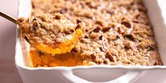 a close up of a spoon in a casserole dish with food on it